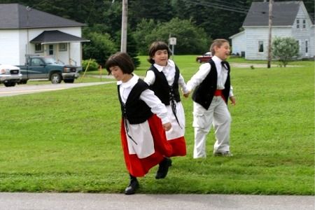 The Jeddry triplets play on grass outside St. Alphonse Catholic Church after the Reunion Mass.